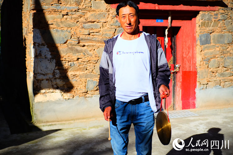 王爾單拿著當(dāng)晚提醒村民的鑼。陳瀟洋攝