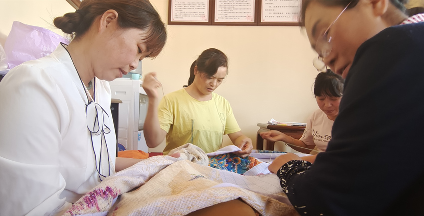 張菊花與繡女們正在趕制“百鳥朝鳳”繡圖。楊奇國供圖