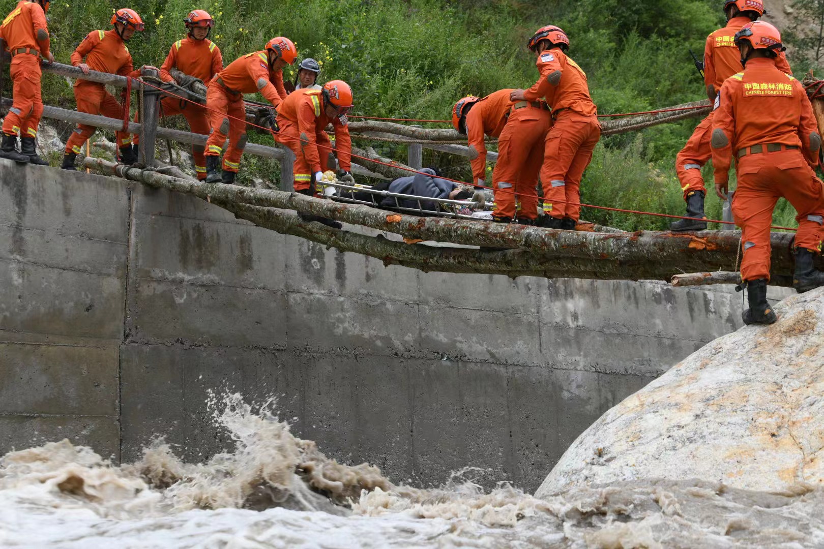 加固簡易橋梁，森林消防員護送傷員就醫(yī)。四川省森林消防總隊供圖