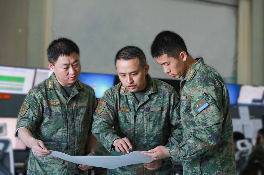 空管保障組成員在一起研究制定飛行管制方案。卜令軍攝