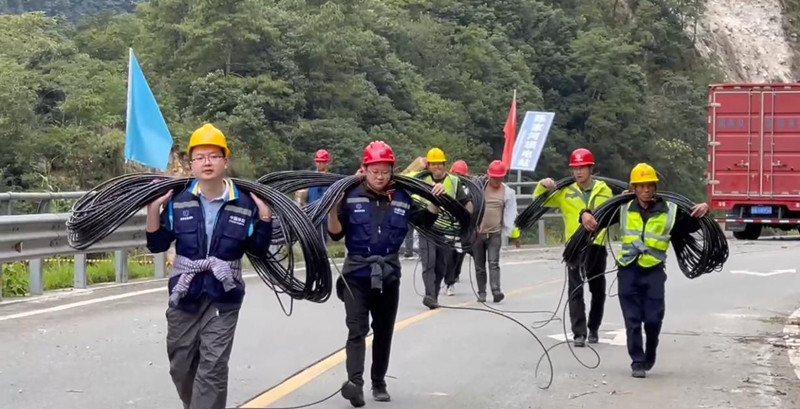 四川移動樂山分公司黨員突擊隊負重徒步前往災區(qū)指定地域。四川省國資委供圖