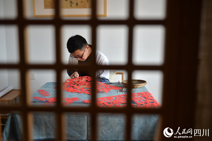 李有生在創(chuàng)作剪紙。王斌攝