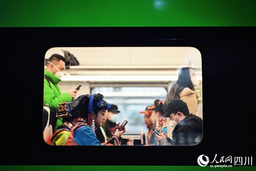 列車內(nèi)，乘客正在查看自己拍攝的列車圖片和視頻。李富彬攝