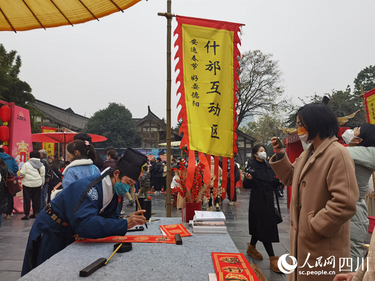 在什邡互動(dòng)區(qū)，為市民寫春聯(lián)。人民網(wǎng) 王波攝