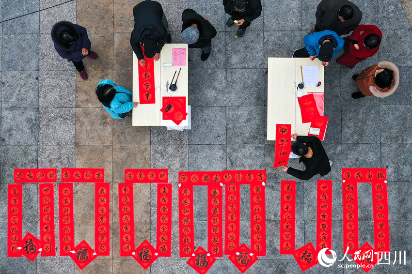 文化志愿者為群眾免費(fèi)寫春聯(lián)。牟科攝